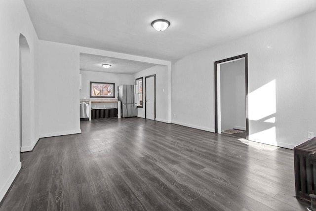 unfurnished living room featuring dark wood-type flooring and radiator