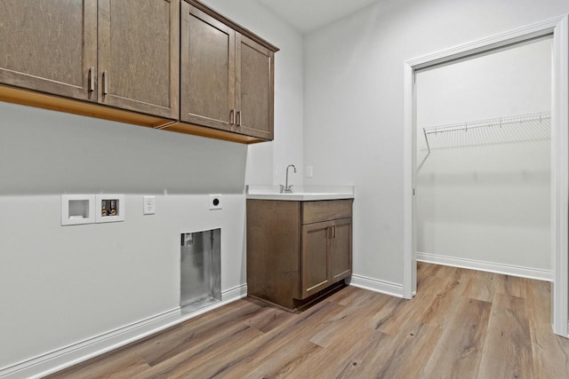 laundry room with cabinets, hookup for an electric dryer, washer hookup, and light wood-type flooring