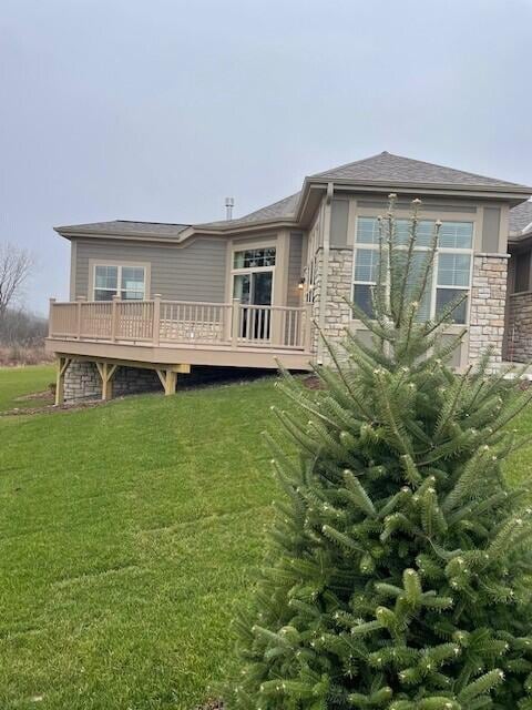 back of house with a wooden deck and a lawn