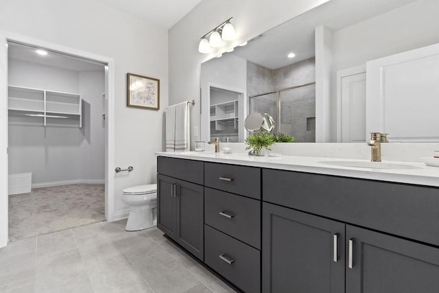 bathroom featuring vanity, a shower with door, and toilet