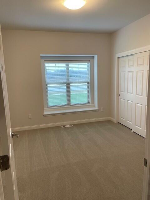 unfurnished bedroom with carpet floors and a closet