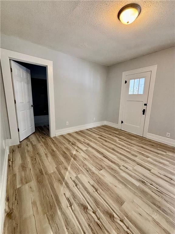 entrance foyer with a textured ceiling and light hardwood / wood-style flooring