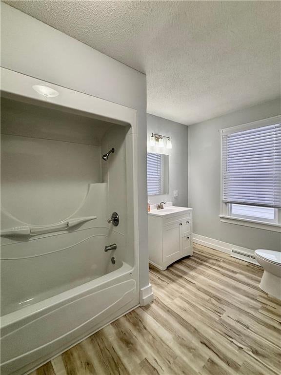 full bathroom featuring vanity, hardwood / wood-style flooring, shower / tub combination, and toilet