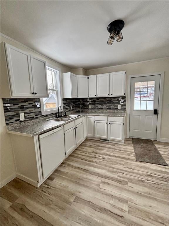 kitchen featuring white cabinetry, white dishwasher, light hardwood / wood-style floors, and sink