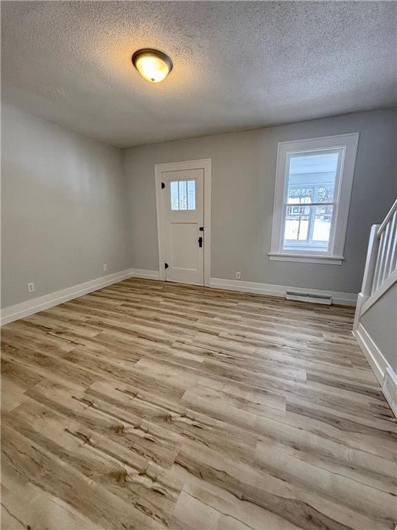 entryway featuring light hardwood / wood-style floors and a textured ceiling