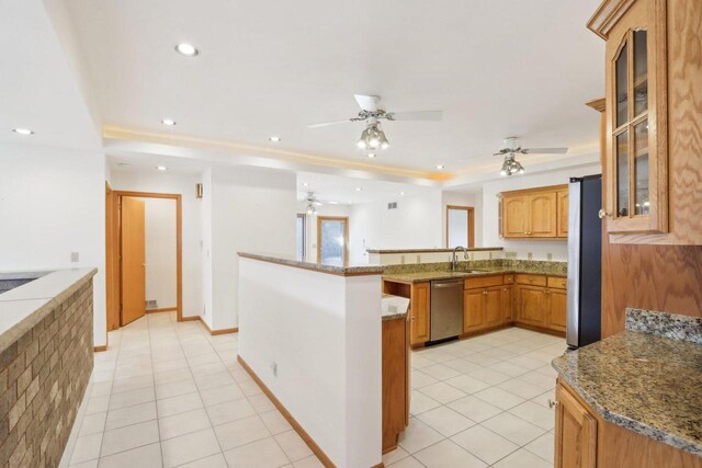 kitchen with stainless steel appliances, kitchen peninsula, ceiling fan, and light tile patterned flooring