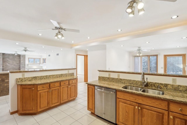 kitchen with light stone counters, sink, plenty of natural light, and stainless steel dishwasher