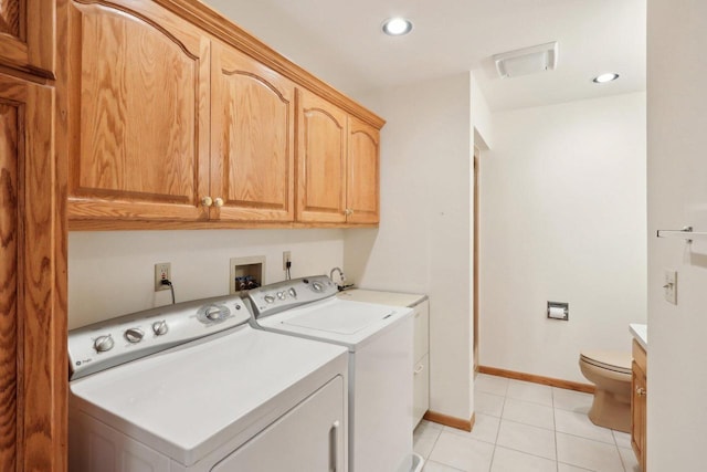 clothes washing area with light tile patterned floors and washer and dryer
