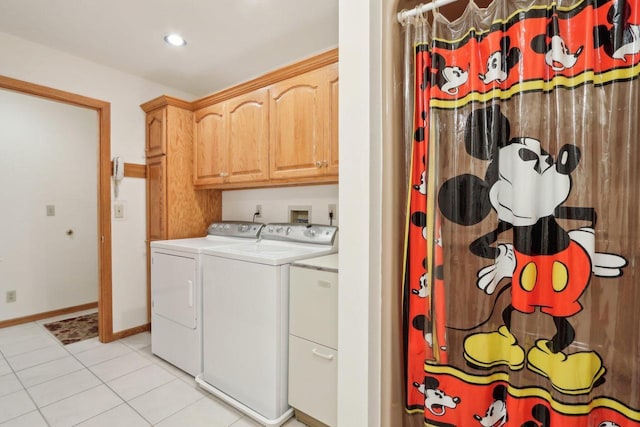 laundry area with cabinets, light tile patterned floors, and washer and clothes dryer