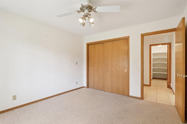 unfurnished bedroom featuring light colored carpet, ceiling fan, and a closet