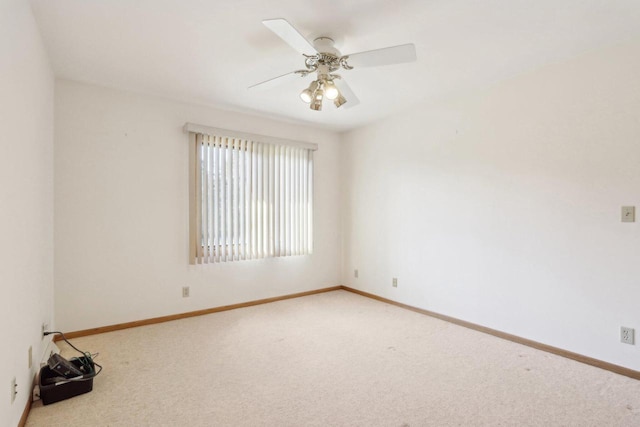 spare room with ceiling fan and light colored carpet