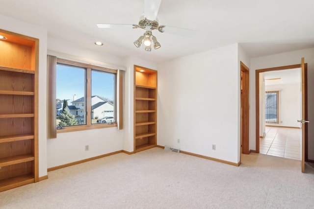 unfurnished bedroom with ceiling fan and light colored carpet