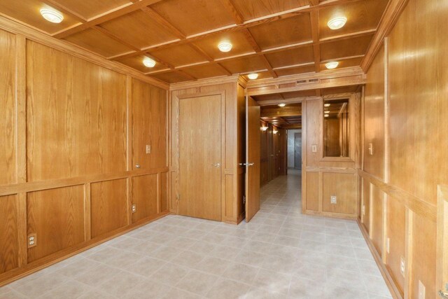 hall featuring coffered ceiling, wooden walls, and wooden ceiling