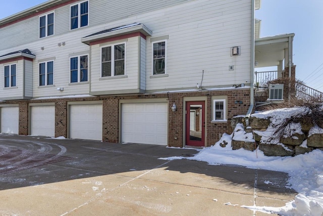 view of front of property featuring central air condition unit and a garage