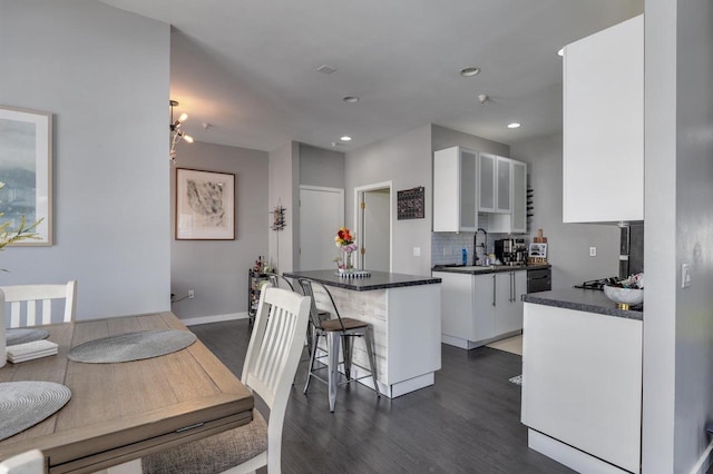 kitchen featuring backsplash, white cabinets, a center island, and dark hardwood / wood-style flooring