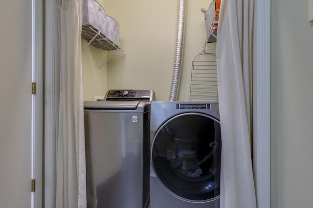 clothes washing area with washing machine and dryer