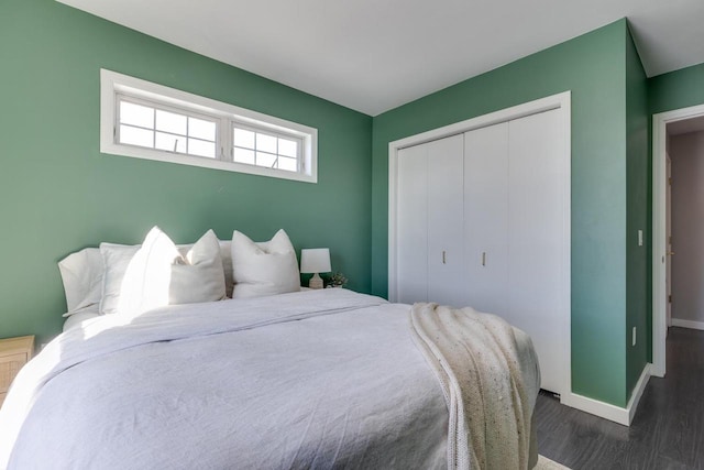 bedroom with dark wood-type flooring and a closet