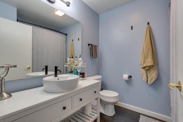 bathroom featuring toilet, vanity, and hardwood / wood-style floors