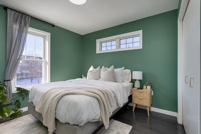 bedroom featuring multiple windows and dark hardwood / wood-style flooring