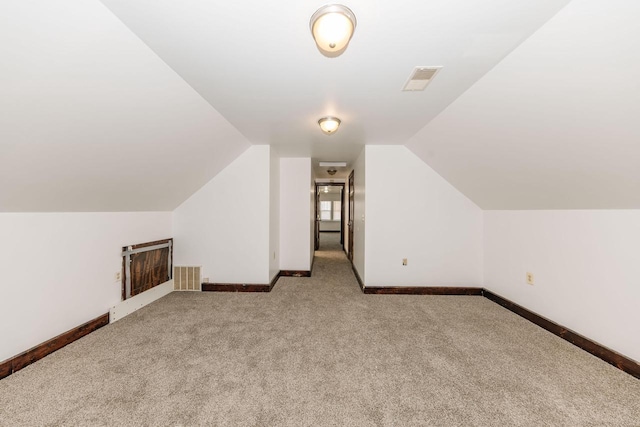 bonus room featuring lofted ceiling and carpet flooring