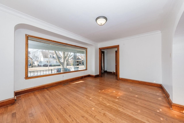 spare room featuring crown molding and light wood-type flooring