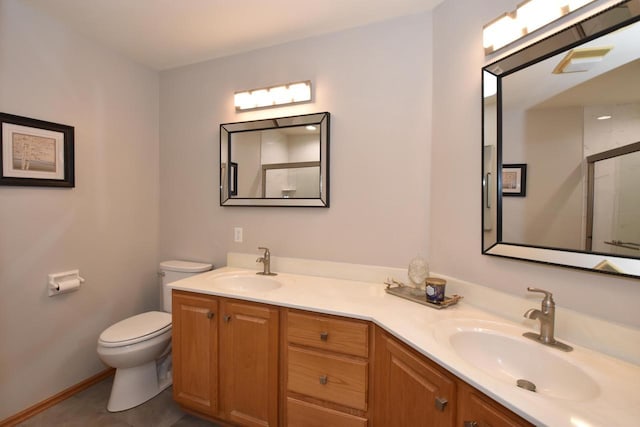 bathroom with vanity, toilet, and a shower with door