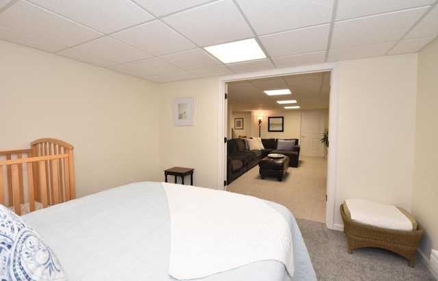 carpeted bedroom featuring a paneled ceiling