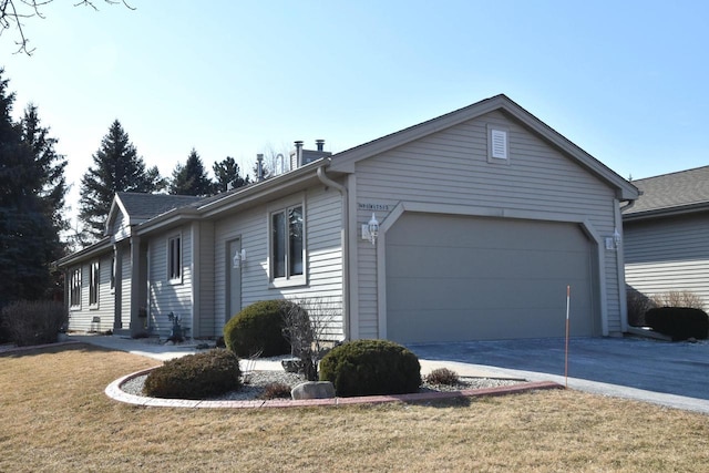 view of side of home featuring a garage and a lawn