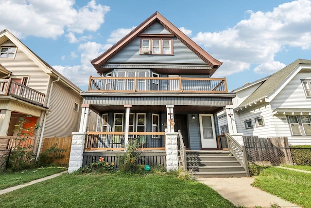 view of front of house featuring a front yard, a balcony, and a porch