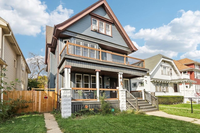 view of front of home with a balcony, a front yard, and covered porch