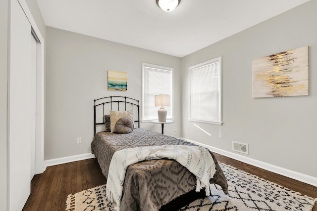 bedroom with dark hardwood / wood-style flooring and a closet