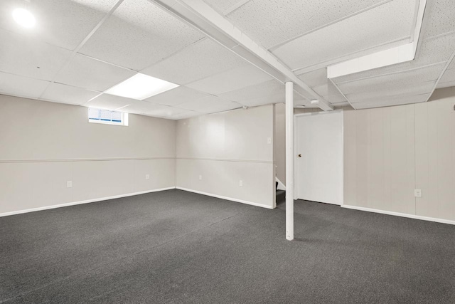 basement with dark colored carpet and a drop ceiling