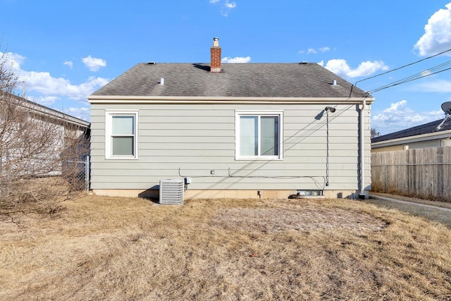 rear view of property featuring a yard and central air condition unit