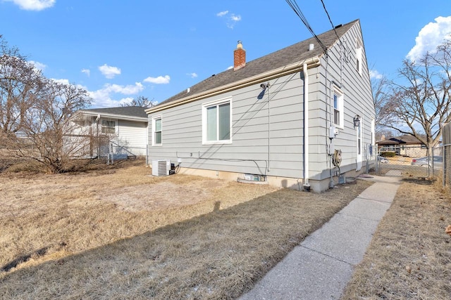 view of home's exterior with central AC and a yard