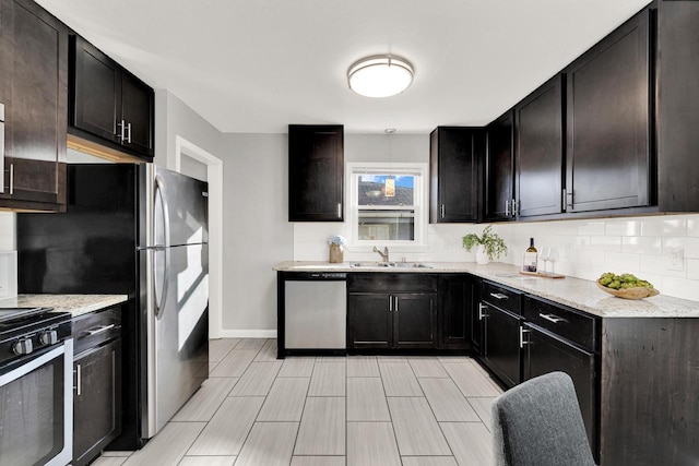 kitchen with sink, appliances with stainless steel finishes, dark brown cabinets, light stone countertops, and decorative backsplash