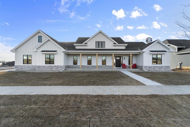 modern farmhouse style home featuring a porch and a front yard