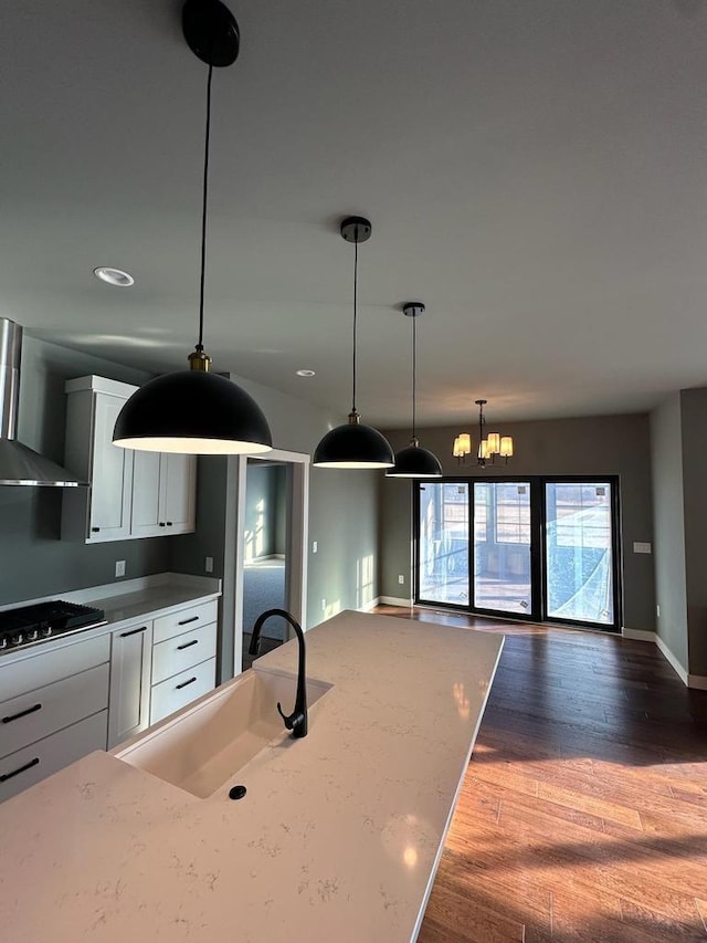 kitchen with sink, gas cooktop, light stone countertops, and white cabinets