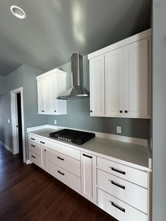 kitchen with white cabinetry, stainless steel gas stovetop, dark hardwood / wood-style floors, and wall chimney range hood