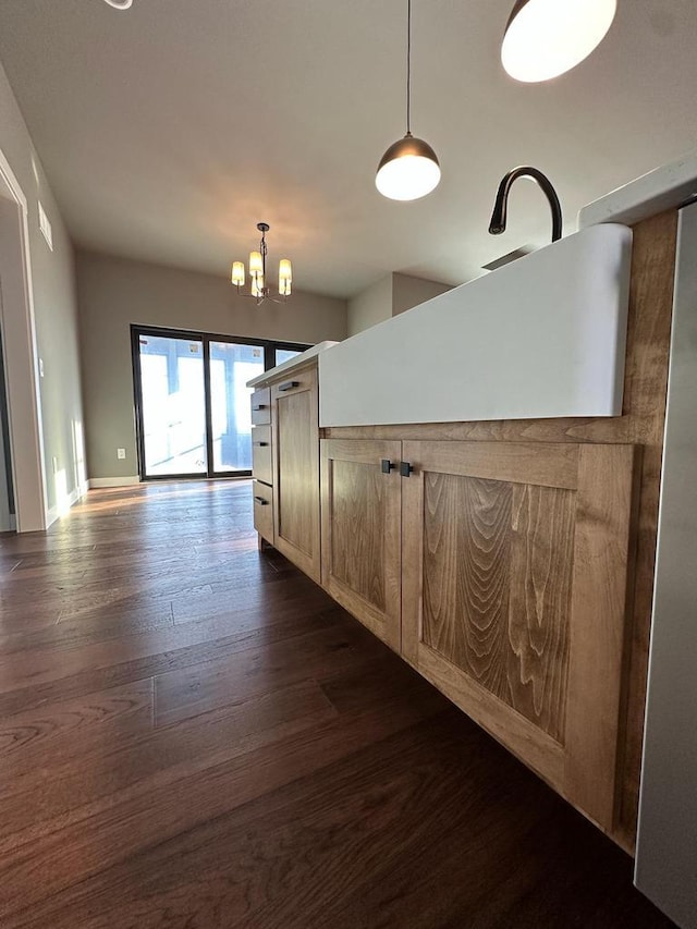 interior space with pendant lighting, dark hardwood / wood-style flooring, and an inviting chandelier