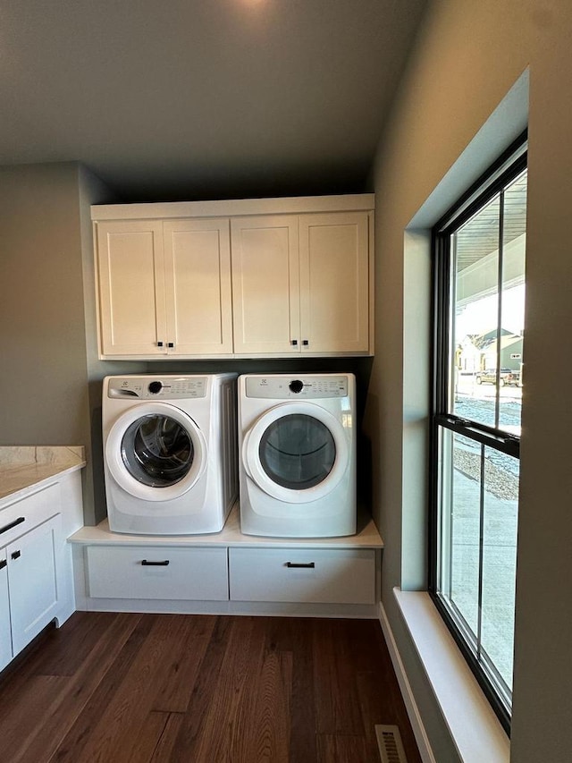 washroom with cabinets, dark wood-type flooring, and washer and clothes dryer