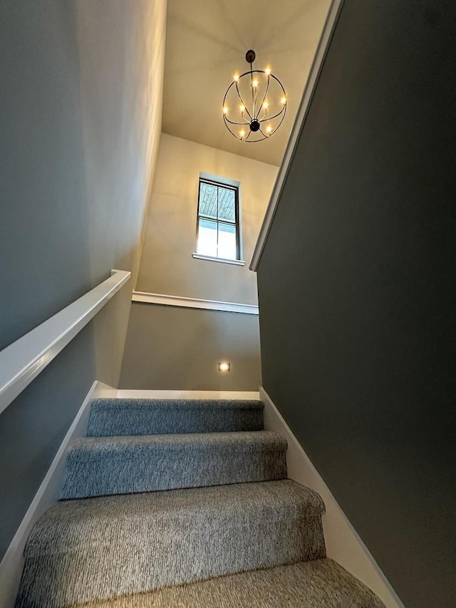 staircase featuring a notable chandelier