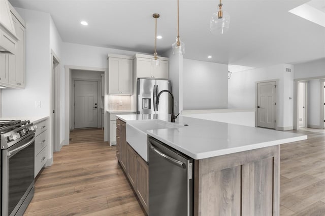 kitchen featuring a spacious island, appliances with stainless steel finishes, decorative light fixtures, and white cabinets