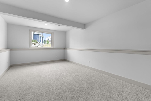 spare room with light colored carpet and beamed ceiling