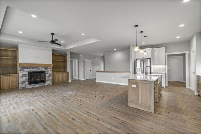 822 Westbridge Trl, Waunakee, WI 53597 - kitchen with stainless steel refrigerator with ice dispenser, decorative light fixtures, a center island with sink, a tray ceiling, and white cabinets
