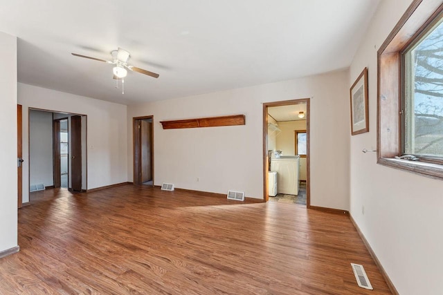 spare room with ceiling fan, washer / dryer, and light hardwood / wood-style floors