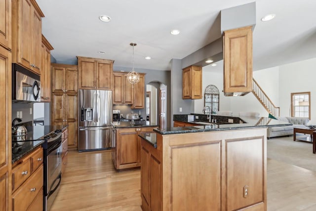 N33W29204 Millridge Rd, Pewaukee, WI 53072 - kitchen featuring light wood-type flooring, stainless steel appliances, pendant lighting, a kitchen island, and sink