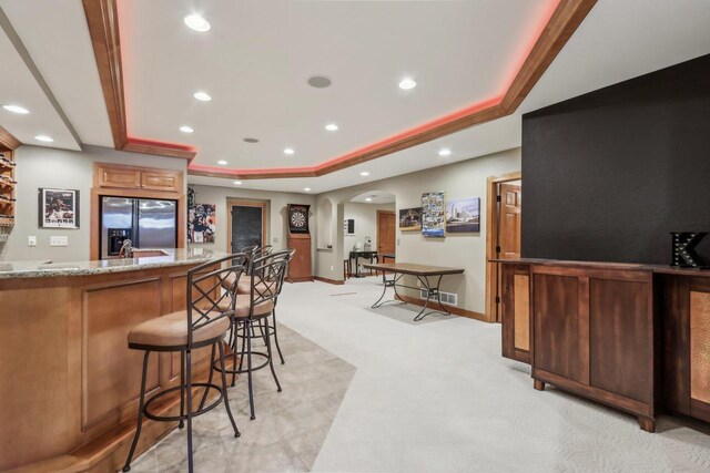 N33W29204 Millridge Rd, Pewaukee, WI 53072 - bar with a tray ceiling, light stone counters, stainless steel fridge with ice dispenser, and light carpet