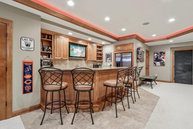 N33W29204 Millridge Rd, Pewaukee, WI 53072 - bar featuring light stone countertops, stainless steel refrigerator with ice dispenser, ornamental molding, and tasteful backsplash