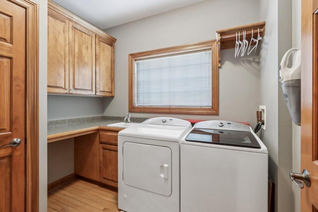N33W29204 Millridge Rd, Pewaukee, WI 53072 - washroom with washing machine and clothes dryer, sink, cabinets, and light wood-type flooring