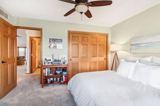 carpeted bedroom featuring ceiling fan and a closet